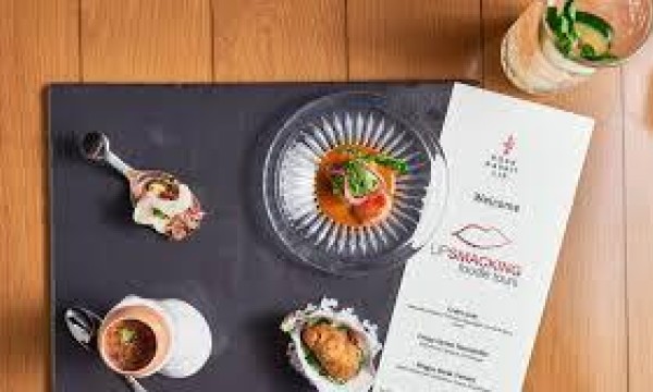 Menu for lip smacking foodie tour with four dishes on a wooden table.