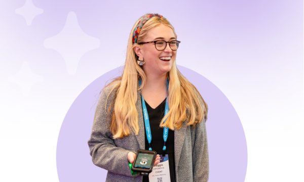 Picture of a happy planner holding her phone on artistic purple background