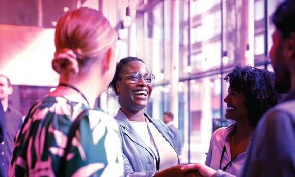 A diverse group of people shaking hands at a networking event, showcasing collaboration and professional engagement.