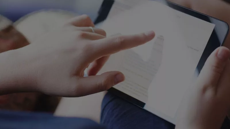 A woman is looking at an employee satisfaction survey on a tablet.