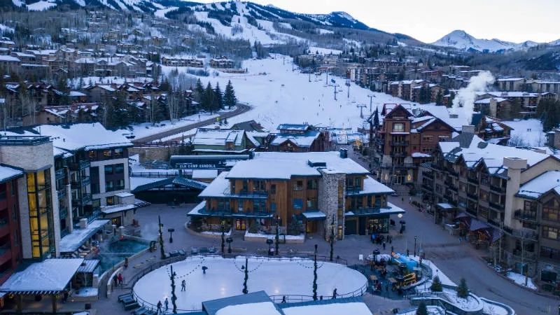 Aerial view of Vail town with snow-covered mountains and buildings in the distance.
