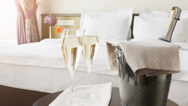 champagne bottle with glasses sitting on hotel room table