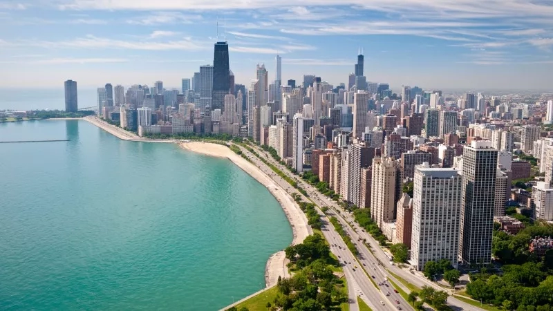 A Chicago skyline view with tall buildings, a road, and a body of water.