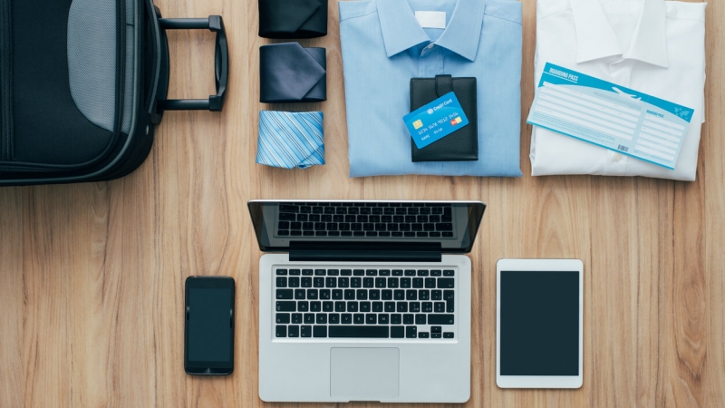 business travel essentials laid out on table for business trip