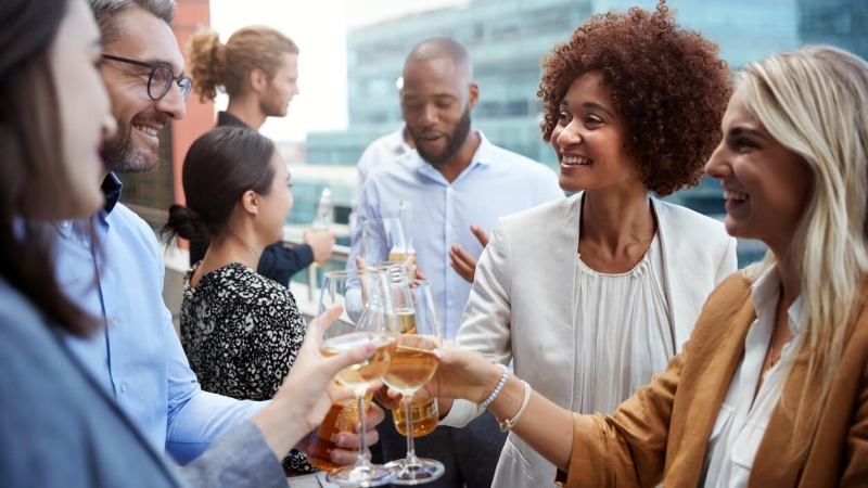 group of people toasting with drinks during happy hour after work