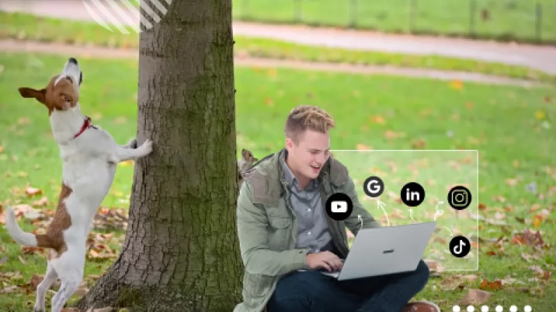 Man and dog in a park with social media icons on a screen in front of the man.
