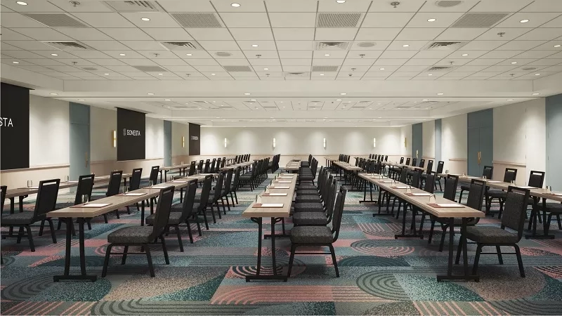 Meeting room with tables and chairs arranged in rows at Sonesta Miami Airport hotel.