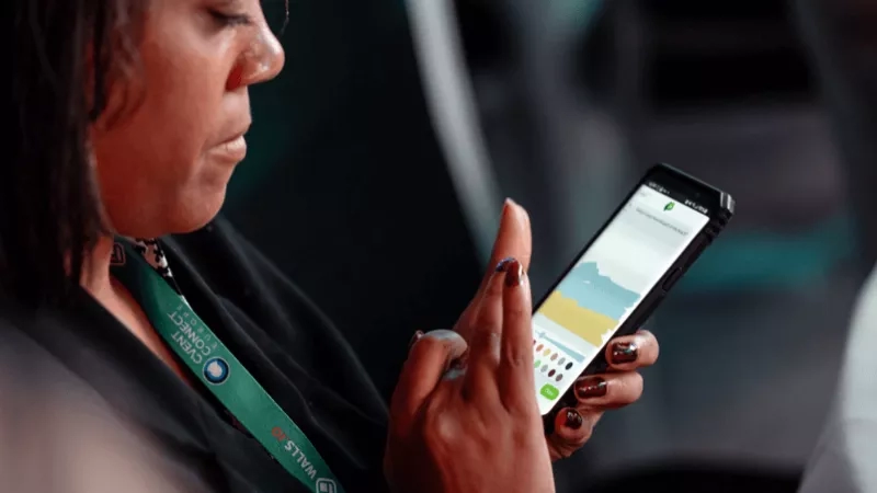 A woman uses a smartphone with an event app on it.