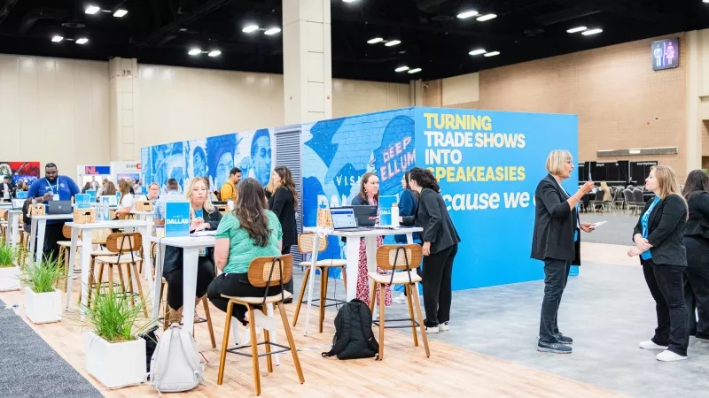 People gathered around tables at Cvent CONNECT 2024, with a "Turning Trade Shows into Speakeasies" backdrop.