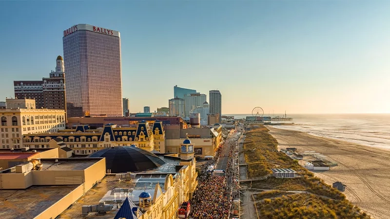 A birds-eye view of the boardwalk and beach in Atlantic City, New Jersey, at sunset.