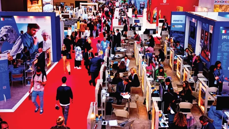 A diverse group of attendees navigating a convention center, showcasing a lively atmosphere filled with activity.