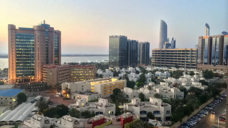 A city view with a group of buildings and a parking lot in front of them.
