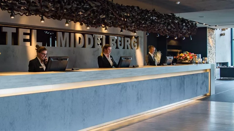 Reception at the Van der Valk Hotel Middelburg, with three receptionists at the counter.
