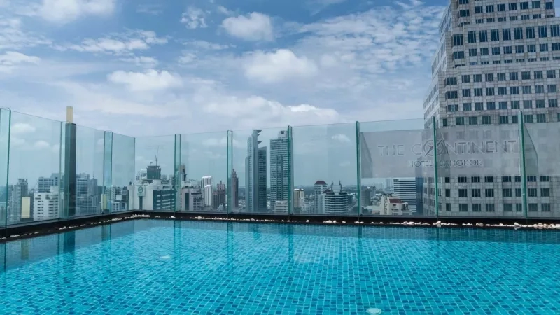 The Continent's infinity pool with stunning views of the city skyline and modern architecture.