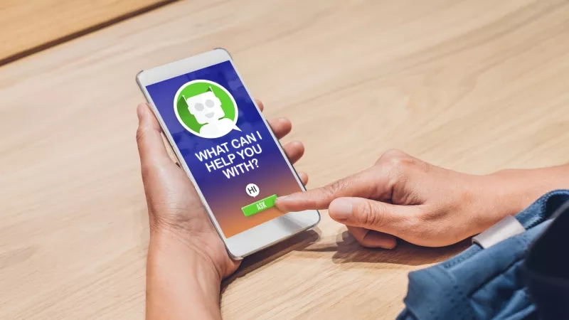 Person using a mobile phone with an AI chatbot asking how it can help them.