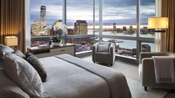 Bedroom at The Ritz-Carlton, New York, NoMad with a view of the city at dusk