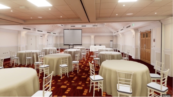 An image of the interior of the meeting hall, featuring round tables and chairs arranged.