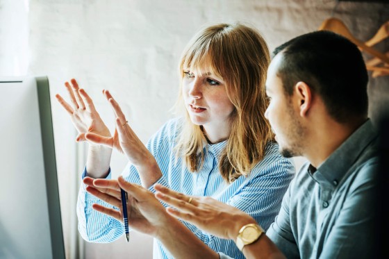 Two colleagues looking at event venue business plan on computer, close up of hands and faces.