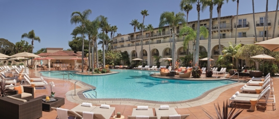 The Dana pool, surrounded by sun loungers and tall palm trees, is part of the Dana Point Resort.