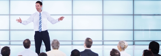Man standing in front of a group of people during a meeting.