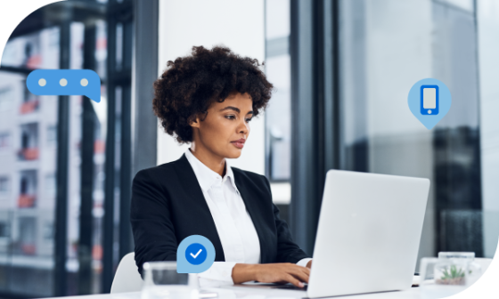 A woman sits at a desk using a laptop with icons floating around her.