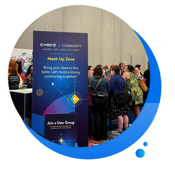 Women at a conference in front of a Cvent sign with text reading, "Meet-Up Zone."