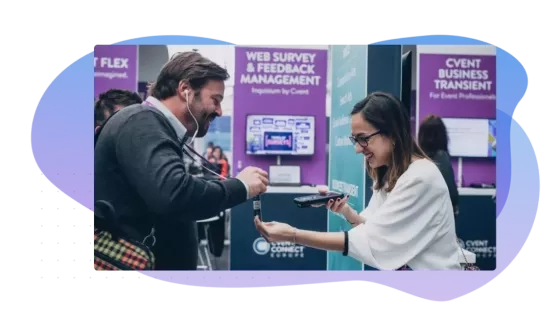 Man and woman at trade show with booth showing web survey and feedback management and event business transient.
