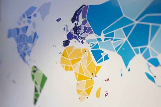 A close up of a colorful world map with geometric shapes in different colors, including blue, yellow, and green.