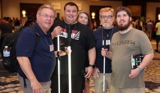 Five blind people with canes posing for a picture at an NFB conference.
