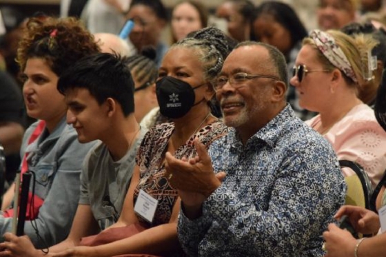 People sit together in a crowded room at the NFB of Michigan's 2023 Annual Meeting.