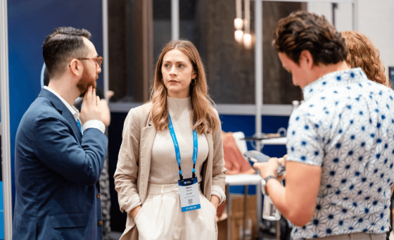 A woman in an event planner uniform stands and talks with a man at an event.