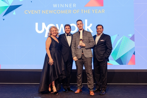 Four people on stage with a winner award for newcomer of the year at Upwork.