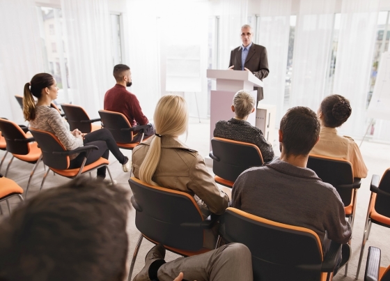Speaker in front of a group of people in a meeting room at the office.