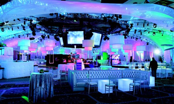 The event hall with a big LED screen and a dance floor with chairs and tables.