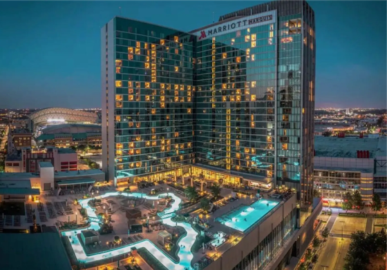 An aerial view of the Marriott Marquis in San Diego at night, showcasing its architecture and pool area.