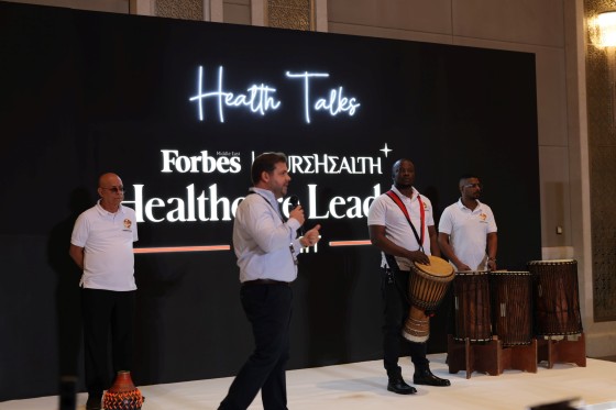 Forbes Health Talks event with live music, speakers, and Forbes branding on a black backdrop.