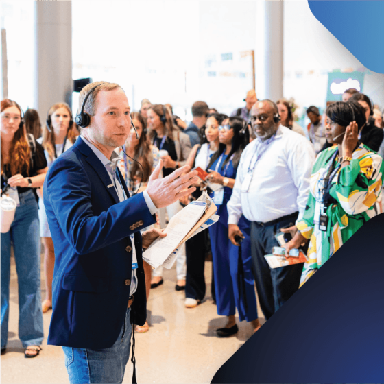 A suited man speaks to a group, sharing ideas and insights.