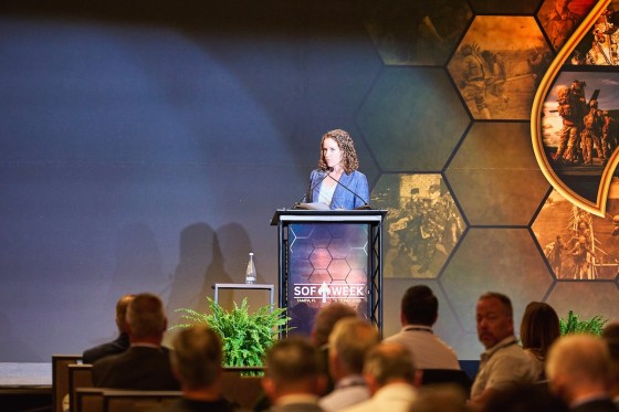 Woman with curly hair speaking at an event for Global SOF