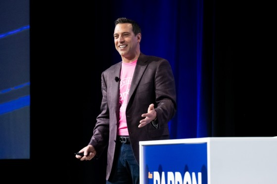 Man speaking on stage in dark suit at Alkami Co:lab conference