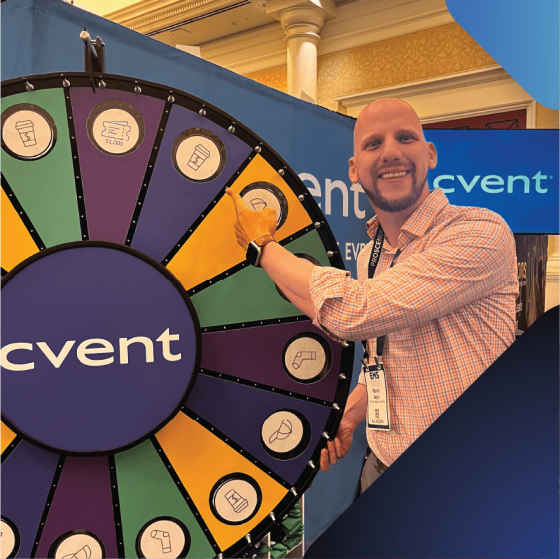 A man stands beside a large wheel labeled "Event," ready to spin for a prize or activity.