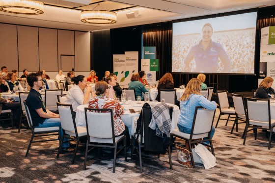 Group of people sitting at the PIEFA event watching a video displayed in front of them.