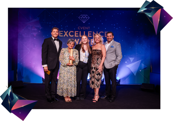 Two women winning award on stage at Excellence Awards