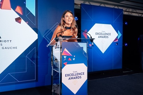 Woman presenting in black tie dress at the Cvent Excellence Awards
