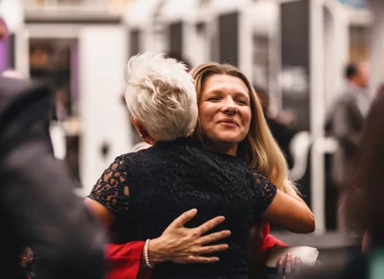 Two attendees hugging and greeting each other