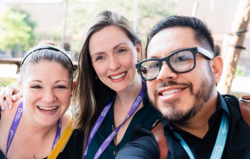 Three people smiling at the camera, wearing name tags with the word "connect" on them.