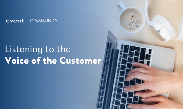 A person typing on a laptop with headphones and coffee on the table beside them.